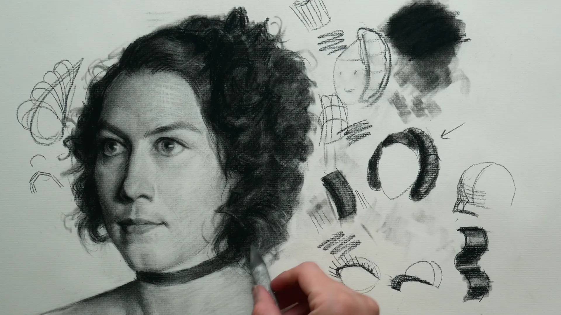 A charcoal portrait demonstration from the course, drawn mid-stroke beside technique studies